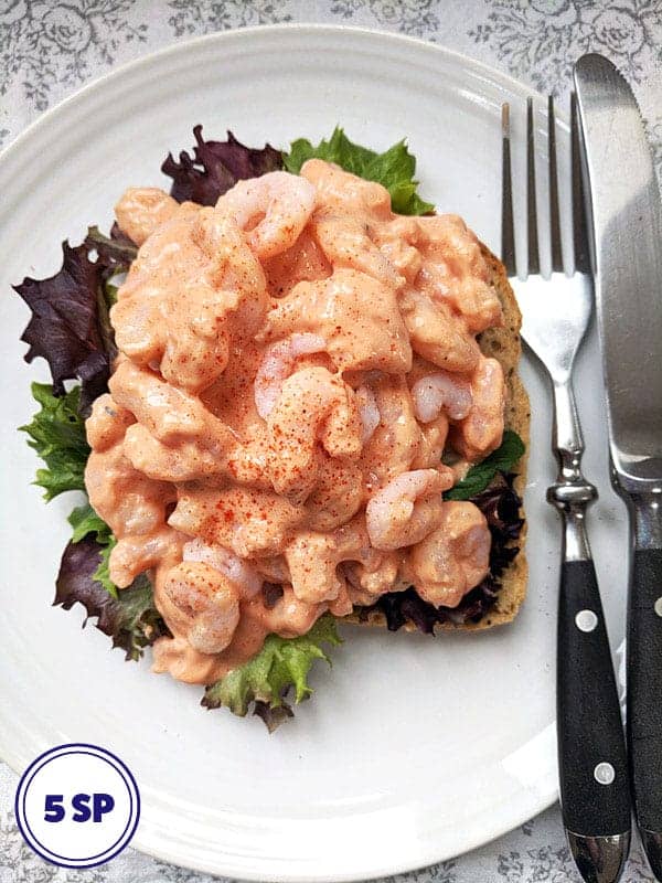 A prawn marie rose open sandwich on a white plate