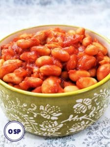 A green bowl full of homemade baked beans