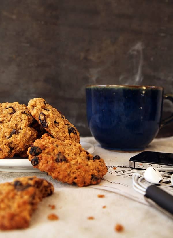 Oat and raisin cookies next to a steaming cup of coffee