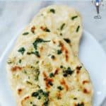 Two garlic naan bread on a white plate