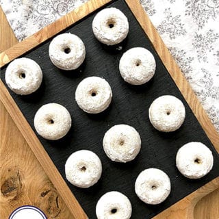 12 mini doughnuts on a black slate board