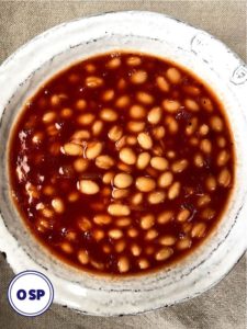 A bowl of baked beans in bbq sauce