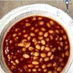 A bowl of beans in a bbq sauce