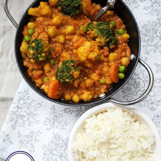 A bowl of chickpea and lentil curry and a bowl of rice