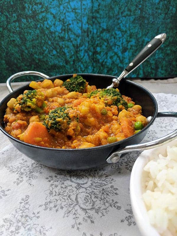 A bowl of chickpea and lentil curry on a white cloth