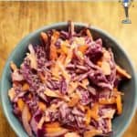 A blue bowl with red cabbage and carrot coleslaw