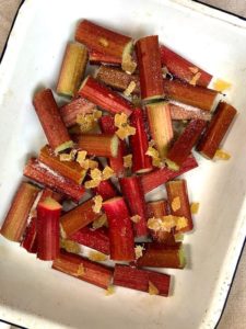 A white oven dish with chopped rhubarb and ginger