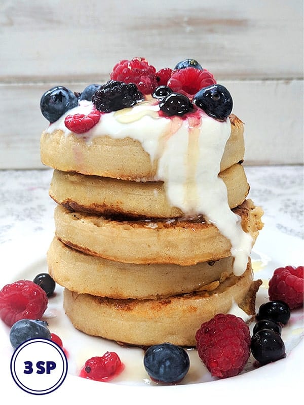 A tower of french toast crumpets topped with yogurt and fruit