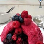 A summer fruit pudding topped with fresh fruit