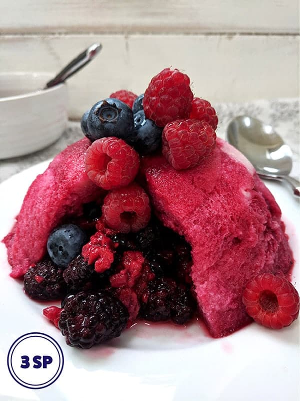 A summer pudding topped with fresh berries 