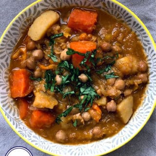 A bowl of vegetable and chickpea broth topped with herbs