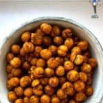 A white bowl full of roasted chickpeas covered in shawarma spice