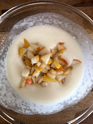 A bowl of pear and raspberry sponge mix