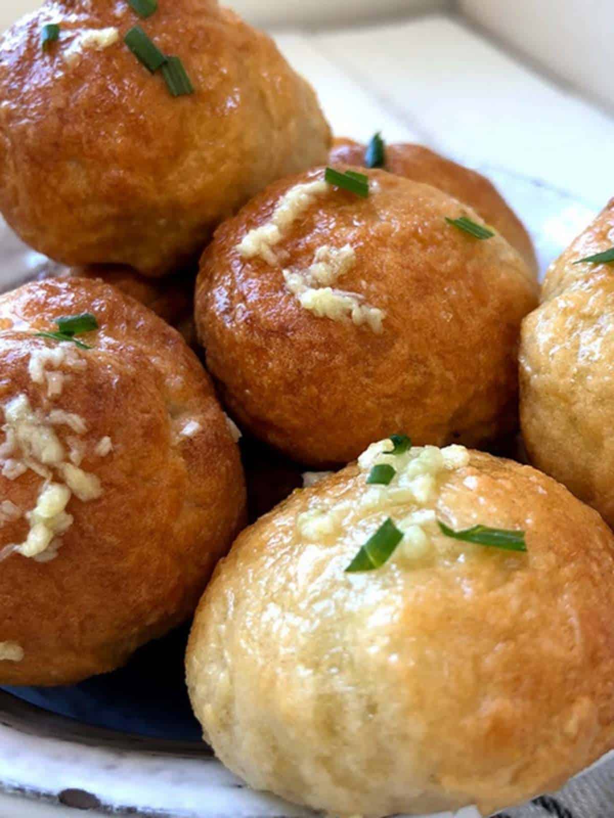 A pile of garlic topped dough balls. 