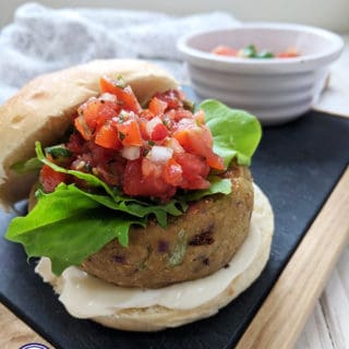 A falafel burger in a bun topped with lettuce & salsa