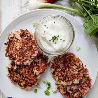 A white plate with 4 radish fritters and a dipping sauce