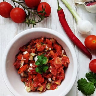 A white dish of salsa with recipe ingredients surrounding it