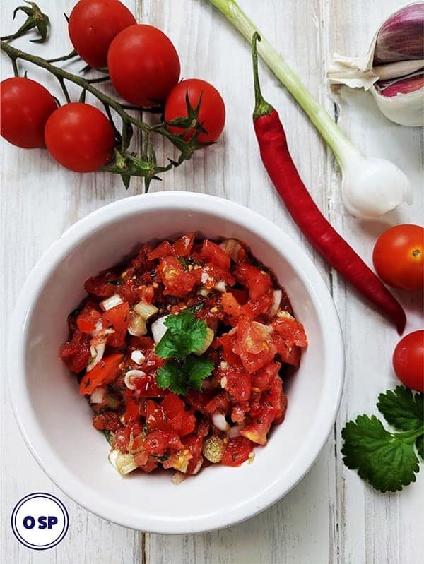 A white dish of salsa with recipe ingredients surrounding it