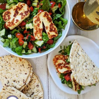 A bowl of salad topped with halloumi cheese