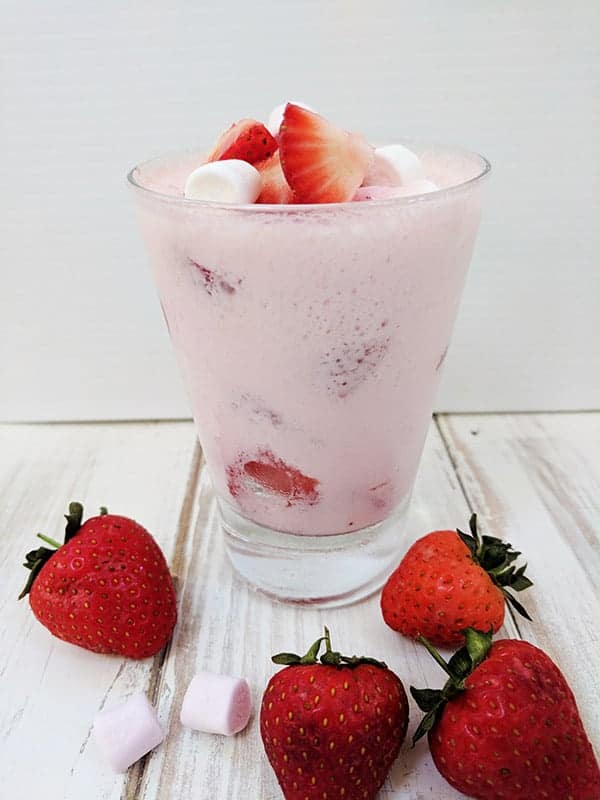 A glass of marshmallow fluff with strawberries