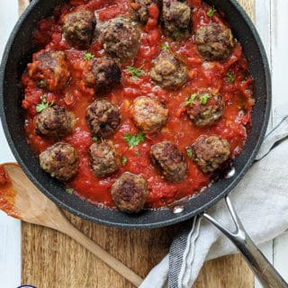 A pan of Italian meatballs on a wooden board