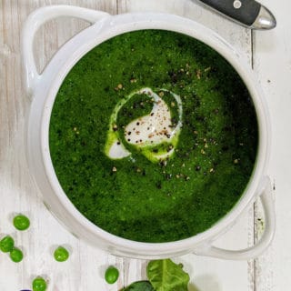 A white bowl full of spinach and pea soup