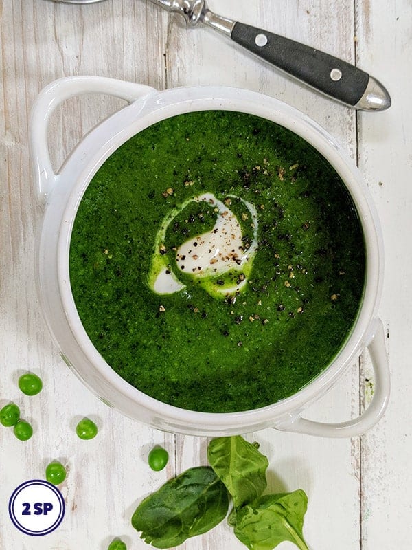 A white bowl full of spinach and pea soup