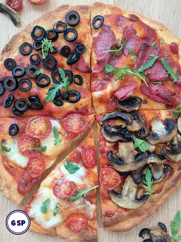 A Four Seasons Pizza on a wooden board