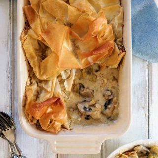 A Chicken leek and mushroom pie on a white table