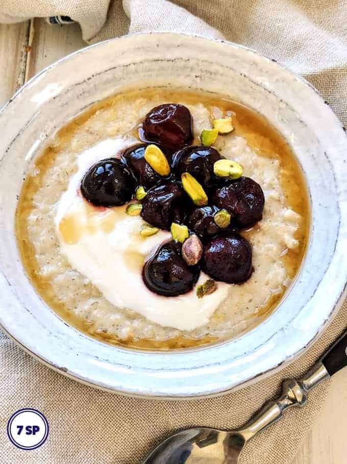 A bowl of porridge with cherries