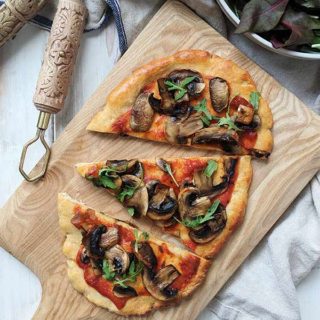 A mushroom pizza on a wooden board