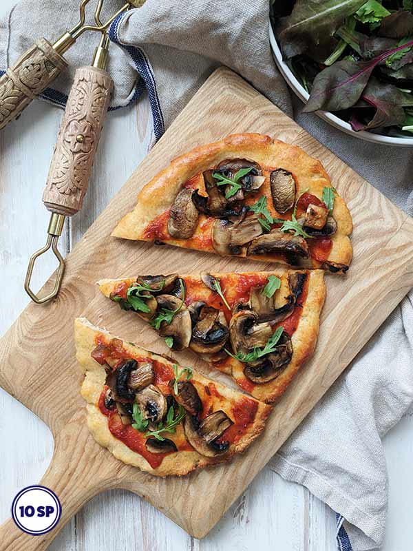 A mushroom pizza on a wooden board