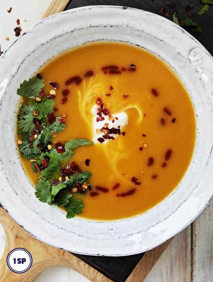 A white bowl filled with thai spiced butternut squash soup