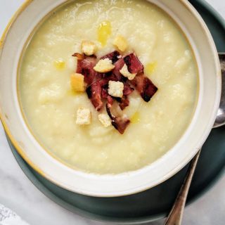 A bowl of celeriac soup with crispy bacon and croutons