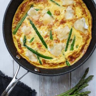 An asparagus and brie frittata on a white table