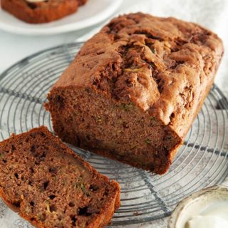 A loaf of Choc Chip Zucchini Bread on a white table