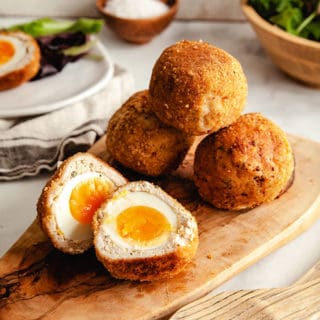 4 Scotch eggs on a wooden platter