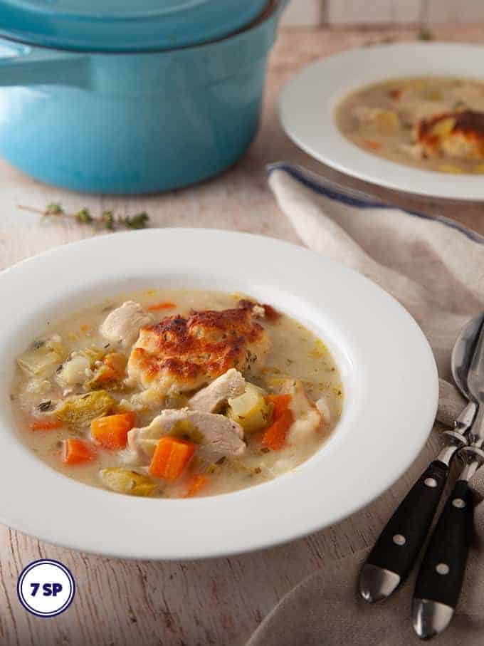 A bowl of easy chicken and dumplings on a wooden board