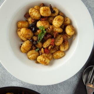 A white bowl of gnocchi pesto