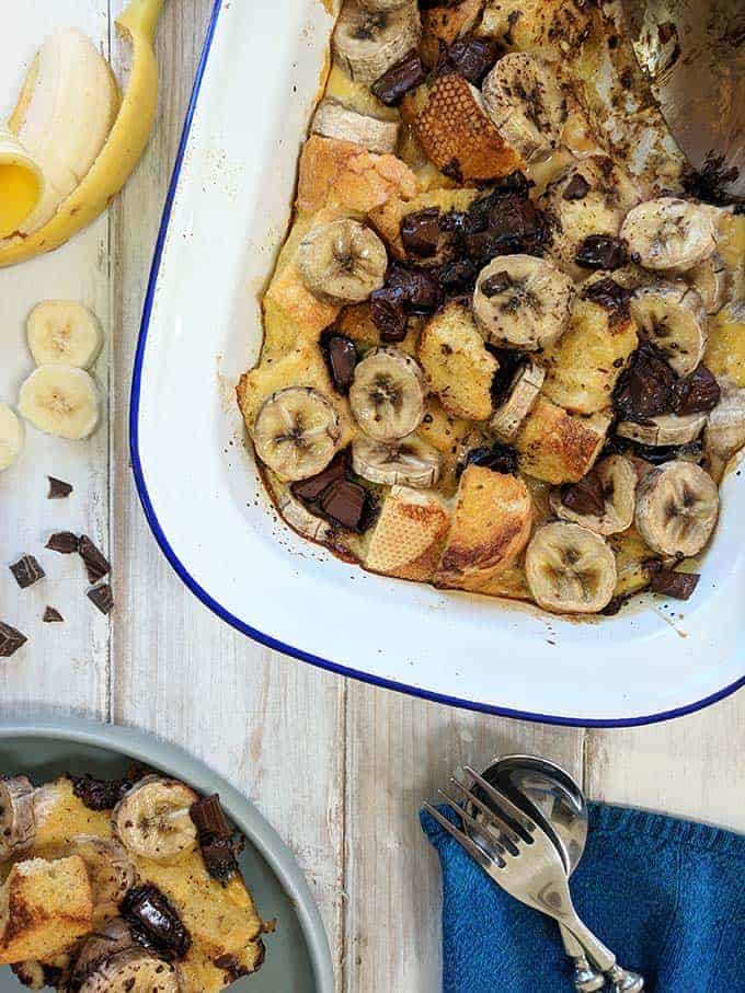 A dish of Bread pudding with banana and chocolate on a white table