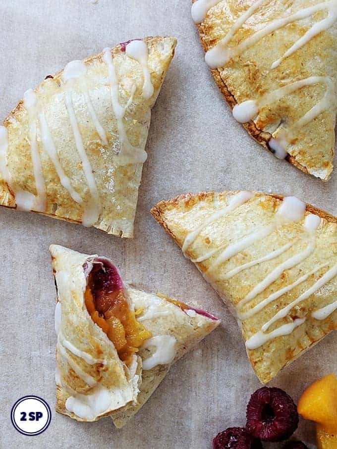 Peach pies on a sheet of parchment paper