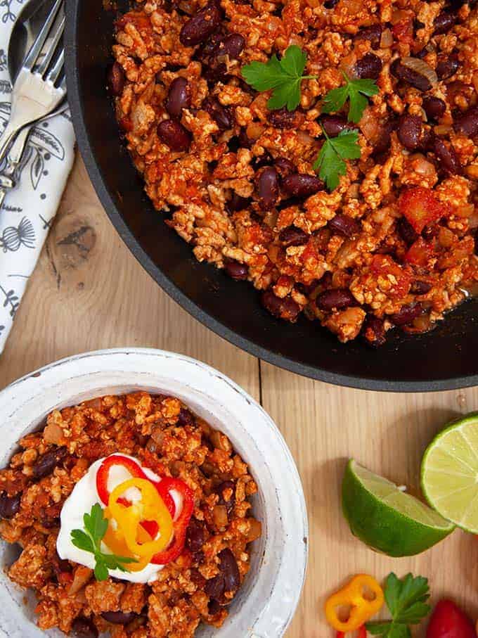 A bowl and skillet of Weight Watchers zero point chili on a wooden table