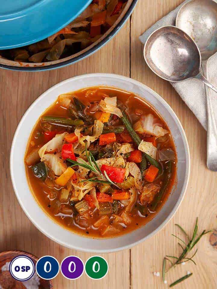 A bowl of cabbage soup on a wooden table