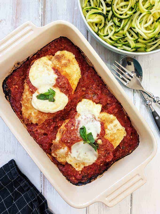 A dish of Chicken Parmesan on a white table | weight watchers