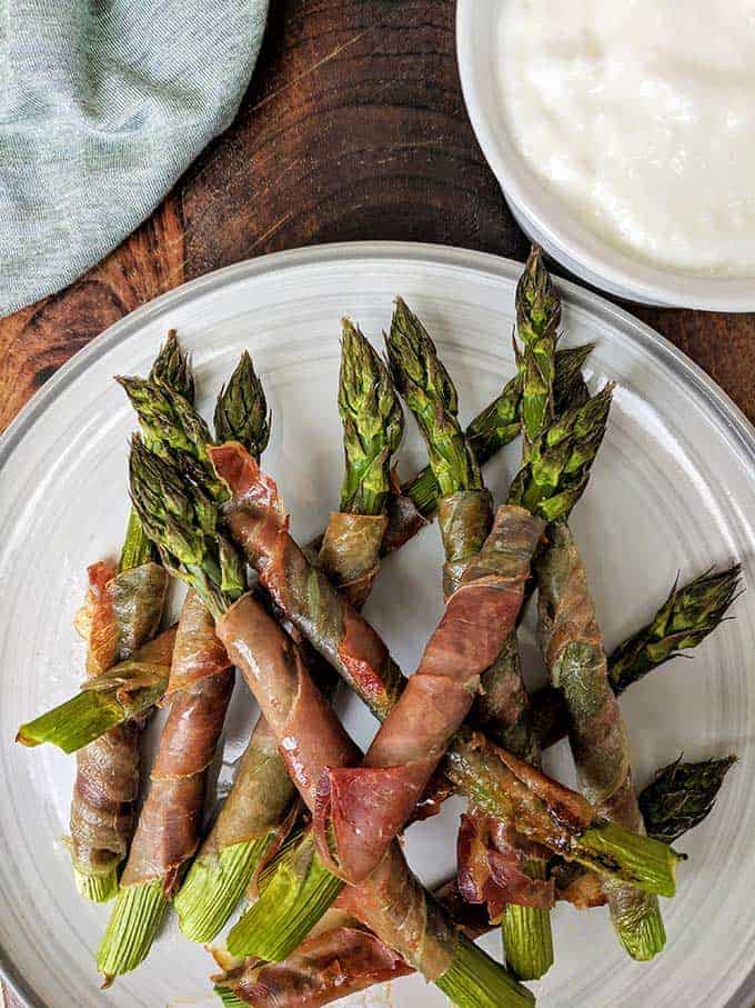 A plate of asparagus wrapped in Prosciutto 