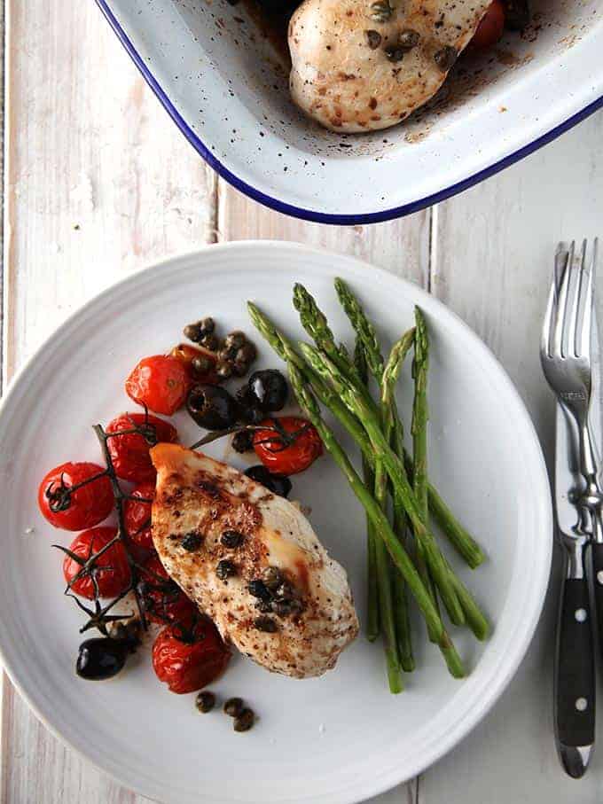 Balsamic chicken on a white plate served with asparagus spears