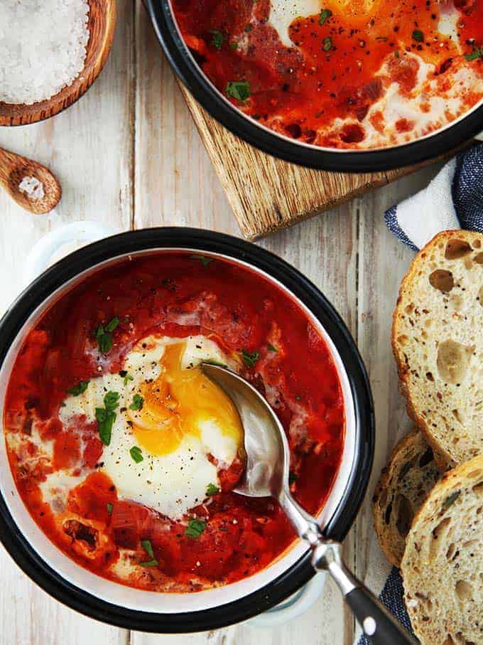 A dish of shakshuka with a spoon in it
