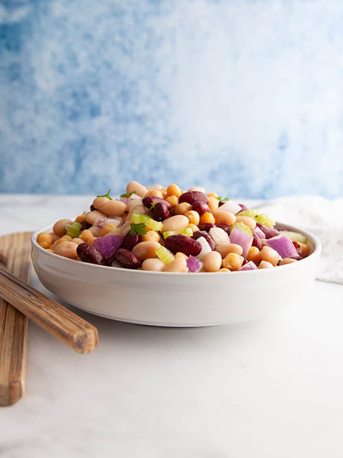 A white table with a bowl of three bean salad