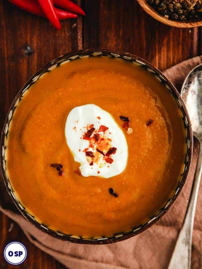 A close up of a bowl of zero point curried pumpkin soup on a wooden table