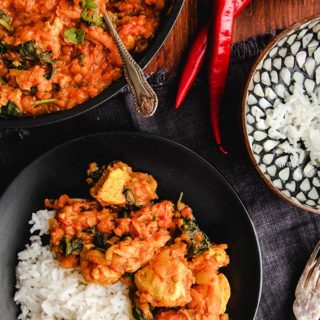 Zero point curry on a black plate with rice with red chilies.